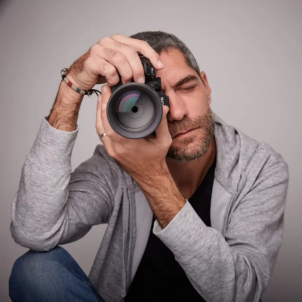 Portrait photographe homme en studio assis decontracte